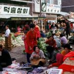 Locals  watch as a gentleman makes his purchase in a busy Chonju marketplace         1/2